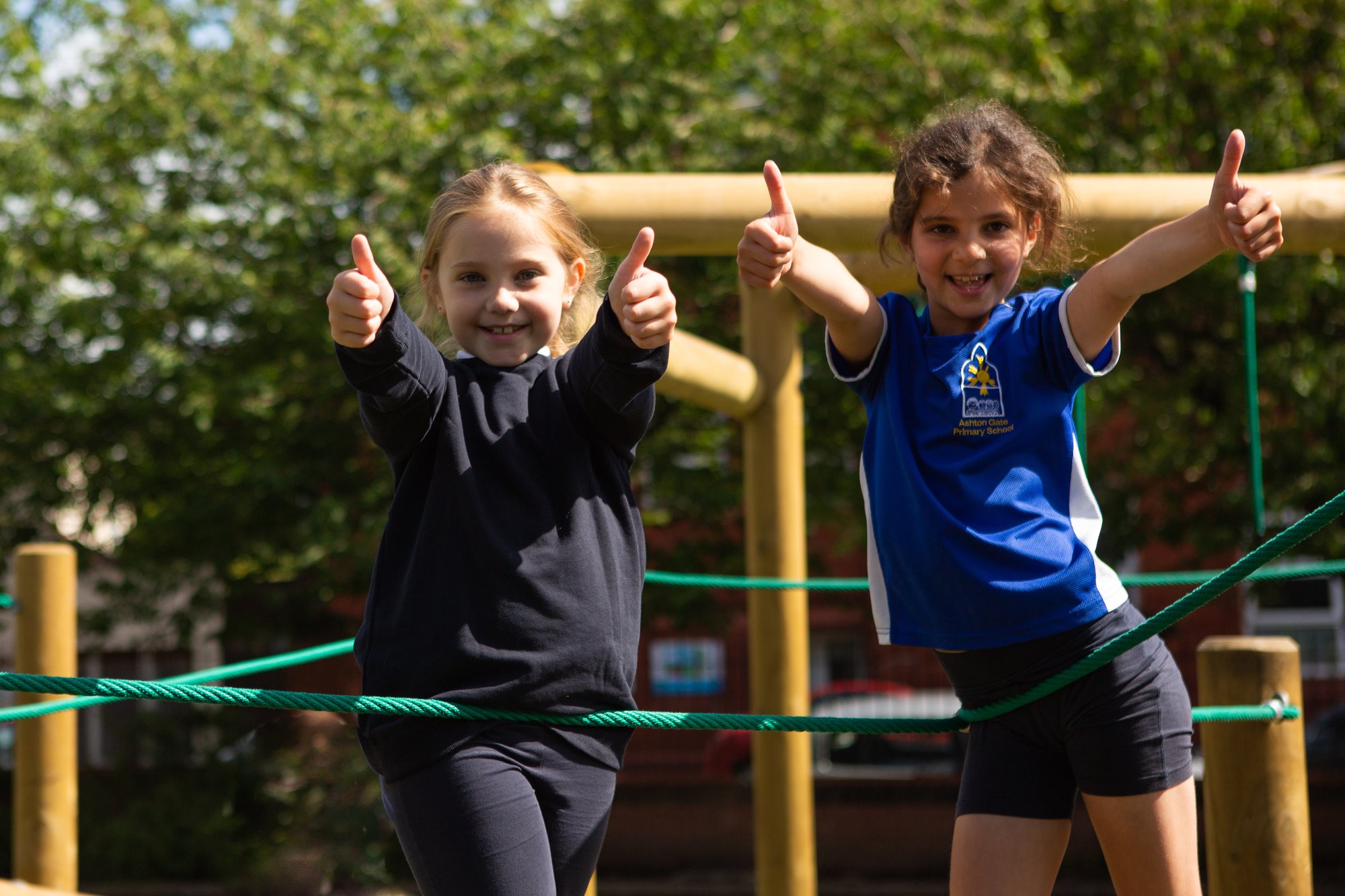 kids with their thumbs up looking happy with their new play equipment