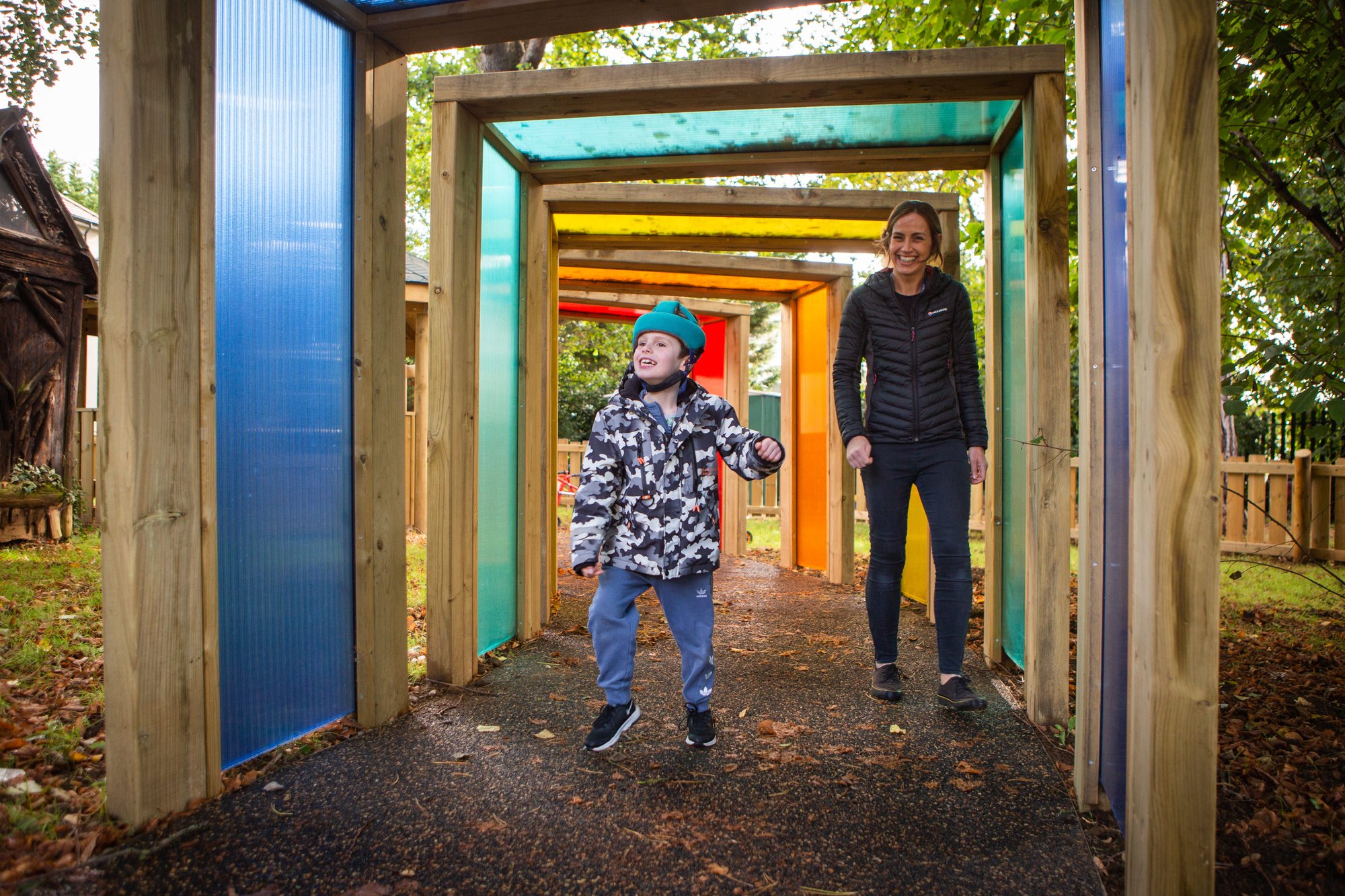 Boy enjoys coloured sensory panels in playground installed by dbdplay at st. rose's school