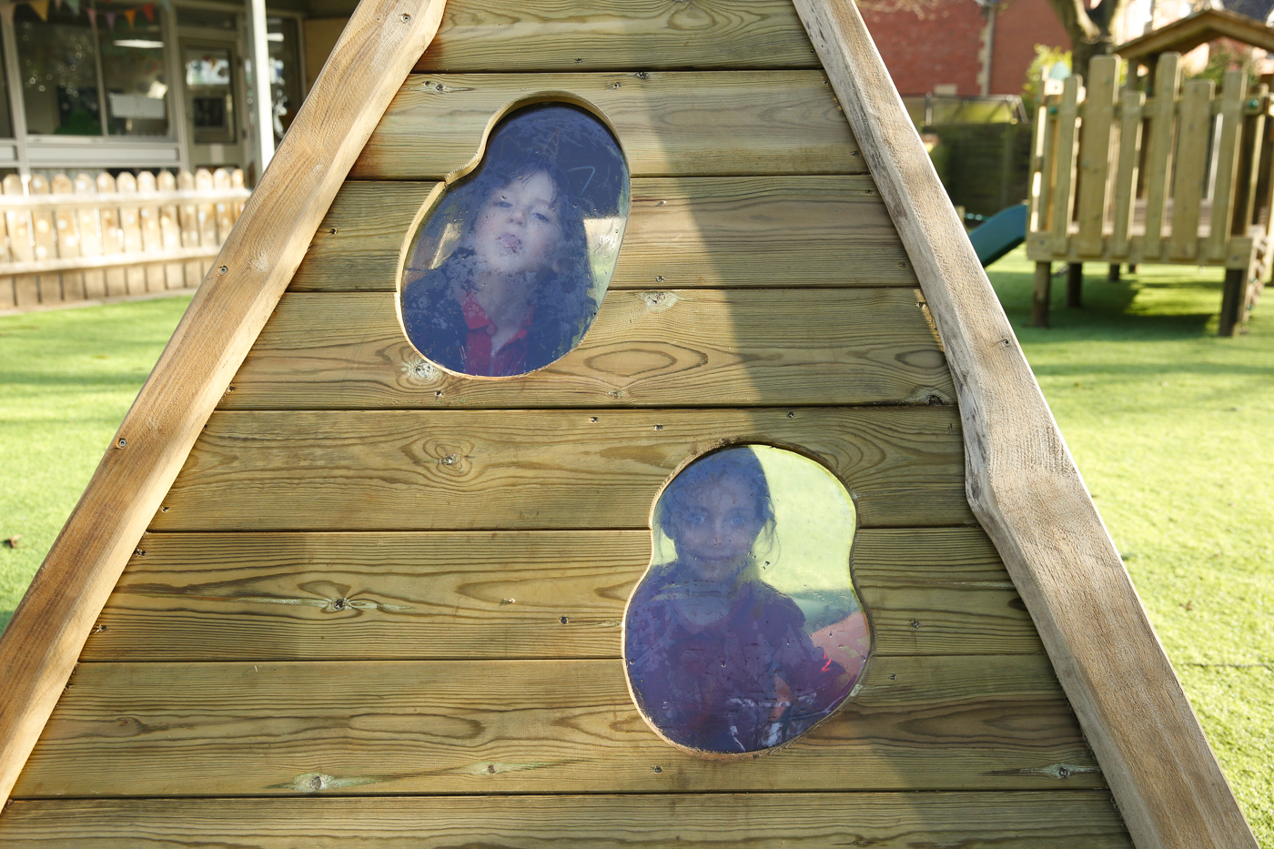 children looking through a window in a timber tower